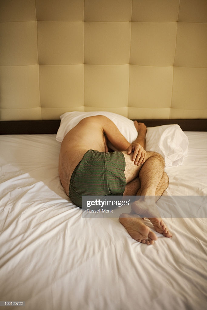 man-lying-in-fetal-position-on-bed-picture-id103120722.jpg