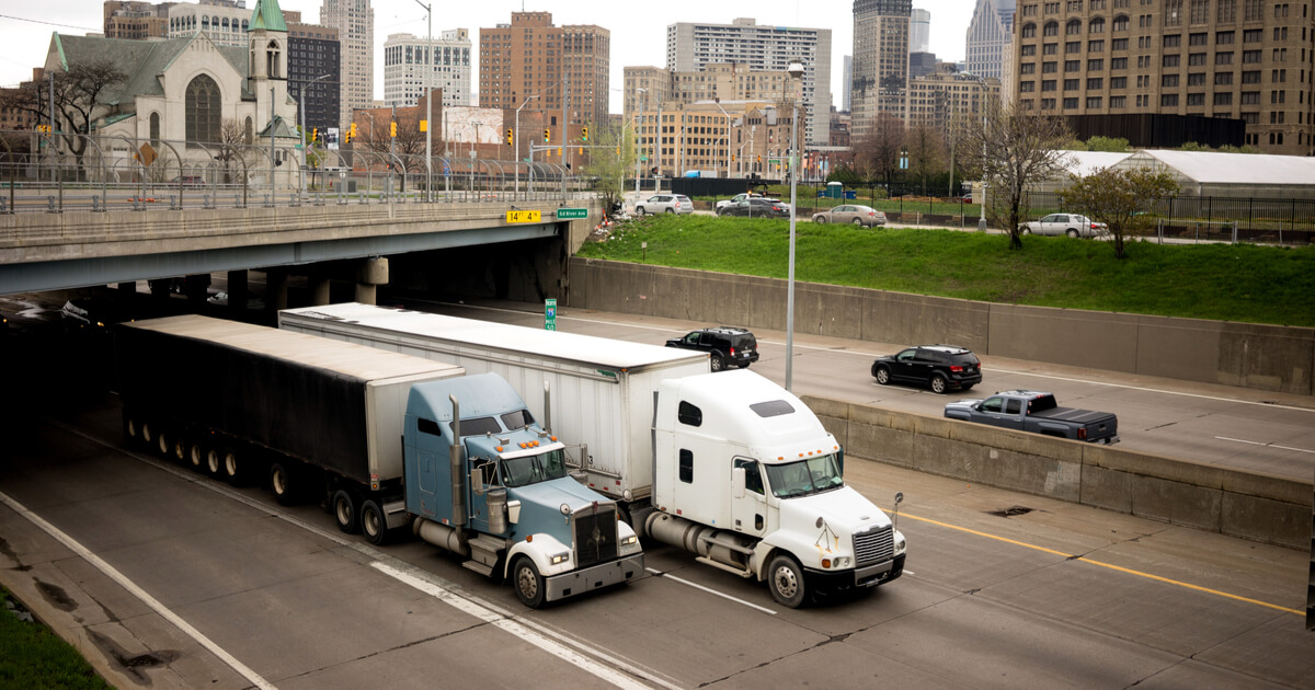 2 semis on highway going through a tunnel