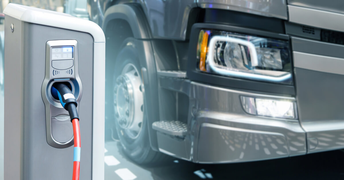 an electric semi truck, charging its battery at a station