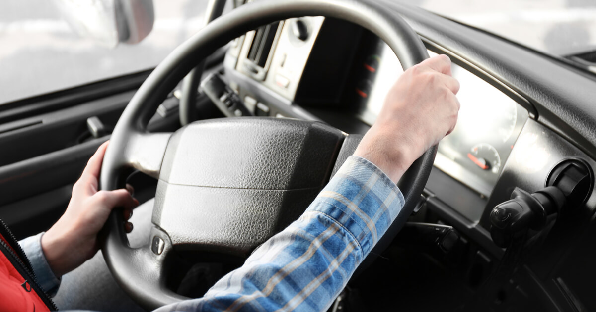 feamle semi truck driver, holding steering wheel