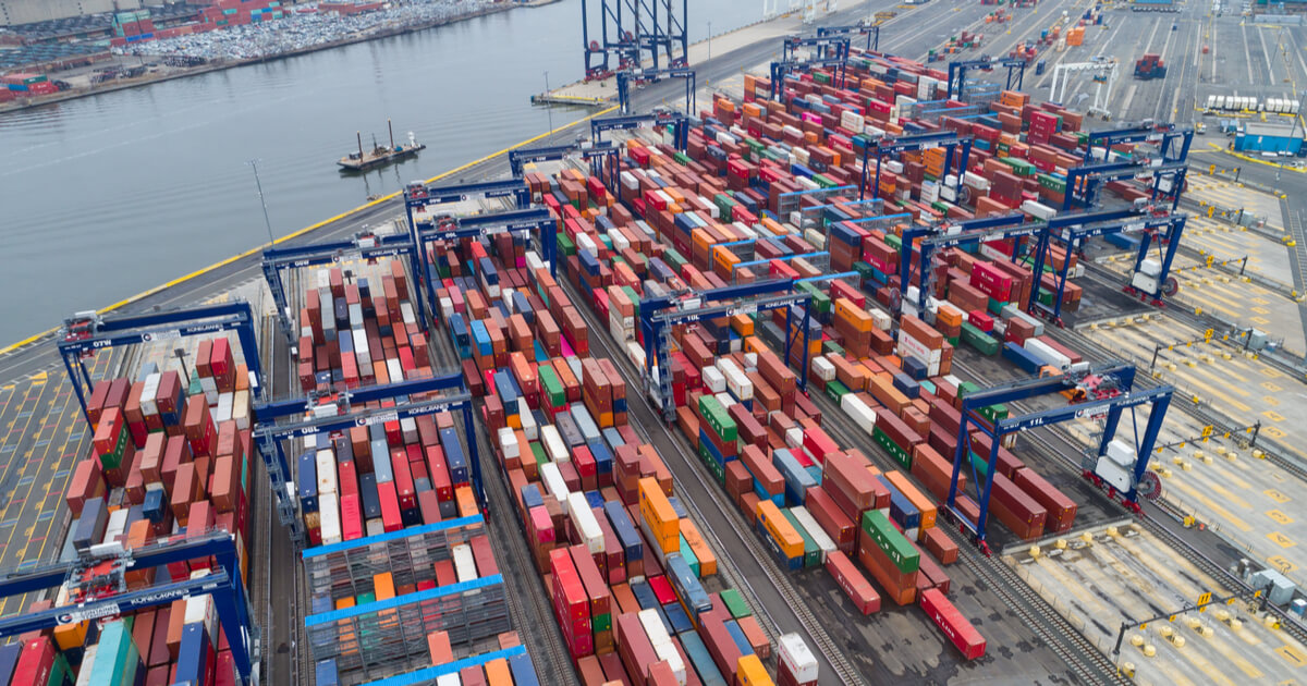 port of new jersey with stacked shipping containers and boats waiting to be unloaded