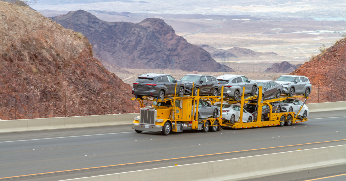 semi truck hauling cars on a desert highway