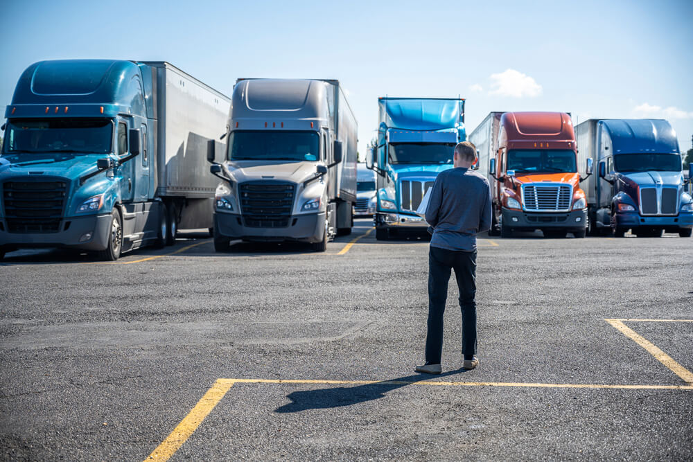 Trucker standing in a semi truck lot