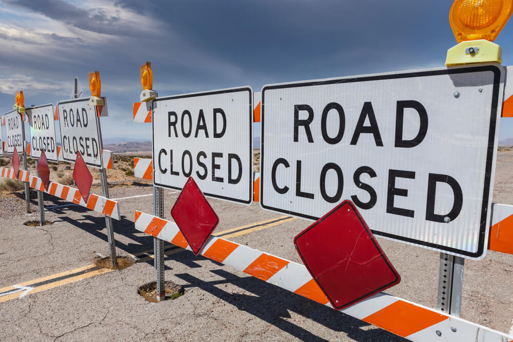 Sign blocking highway in desert