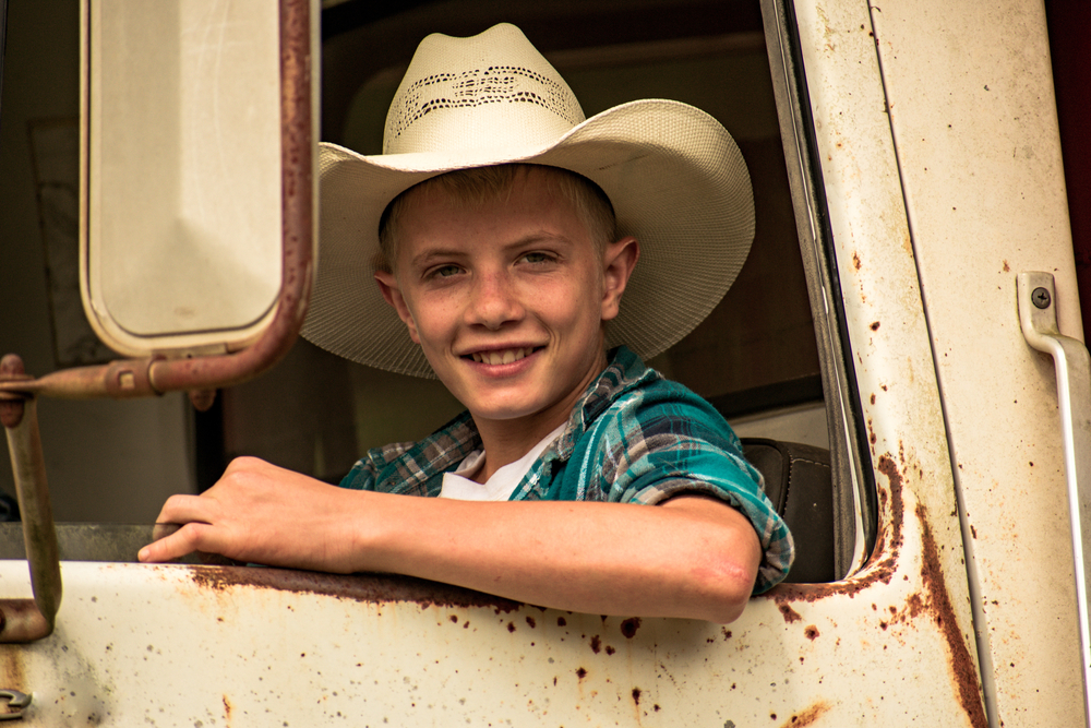 boy in old truck with cowboy hat