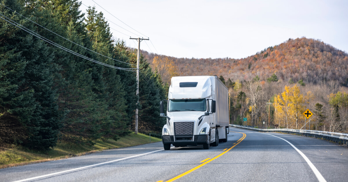 White semi on forested highway